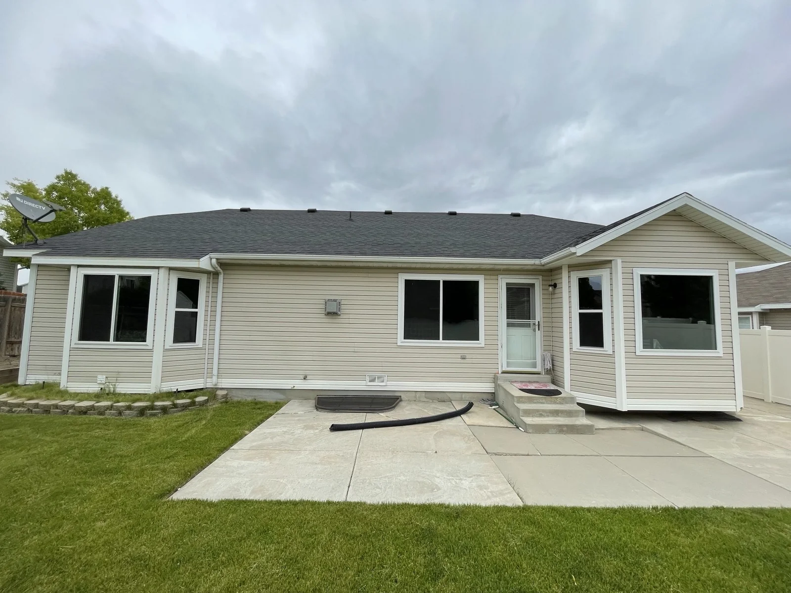White sliding and bay windows on the rear of a siding home