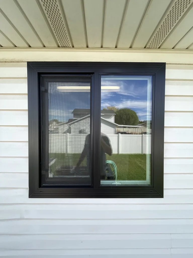 Black frame window on a siding home