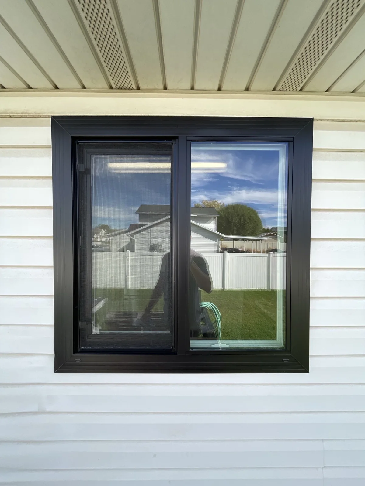 Black frame window on a siding home