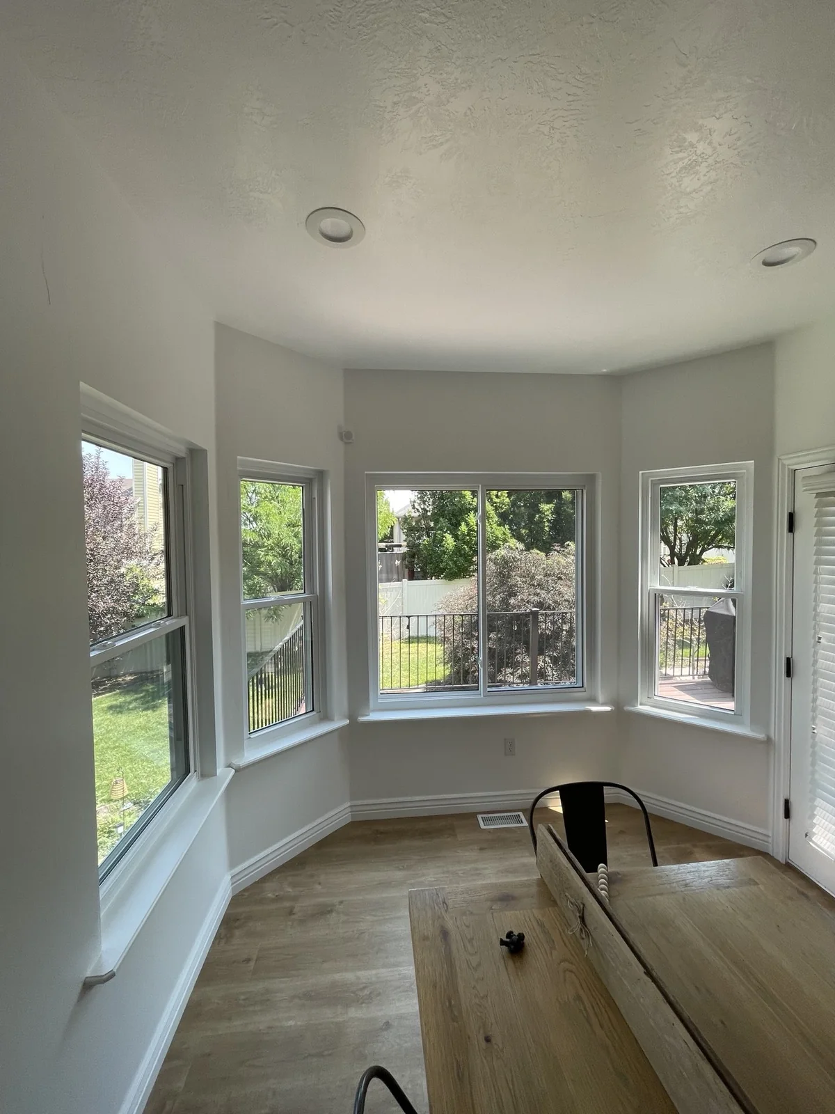 White windows surrounding a bright dining area with garden views